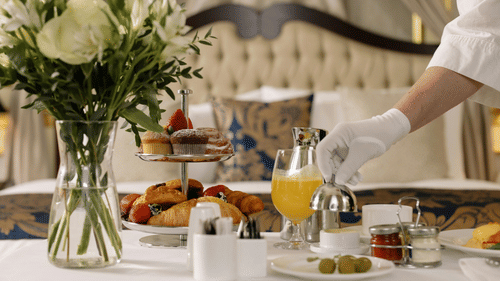 a butler serving food and drinks in a hotel room