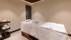 A single, dimly lit spa treatment room with one massage table at The Golden Tusk, Jim Corbett
