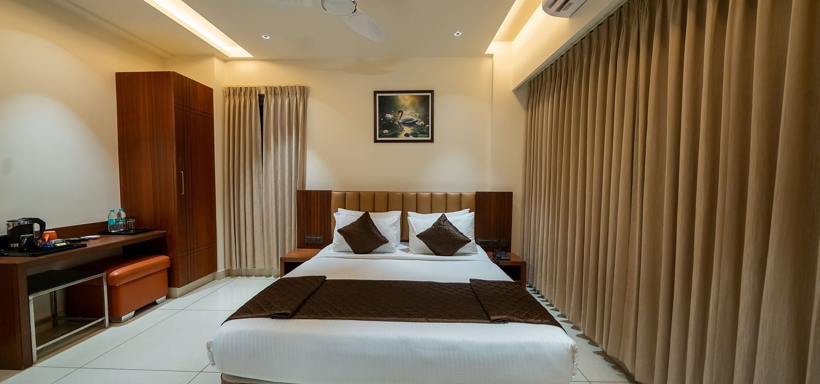 A room featuring a large bed with fully drawn curtains at Hari Govinda's