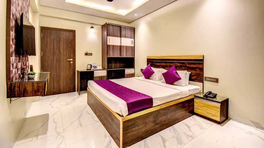 Super Deluxe Room wide view with king bed, wardrobe, TV and marble flooring at VITS Select Kharadi Pune