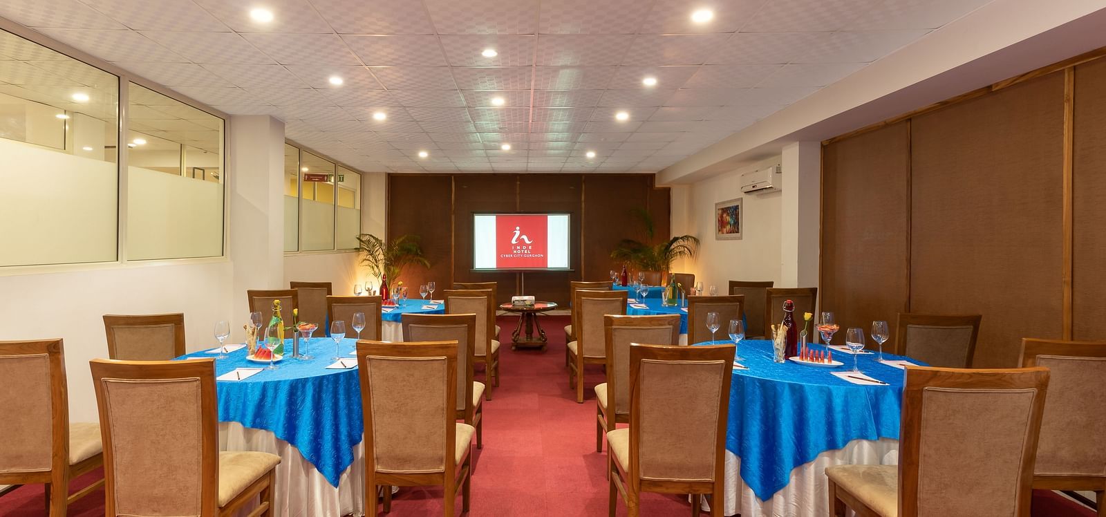 Image of Senate Conference Hall with cluster seating arrangement, blue tables and chairs  | Inde Hotel Cyber City