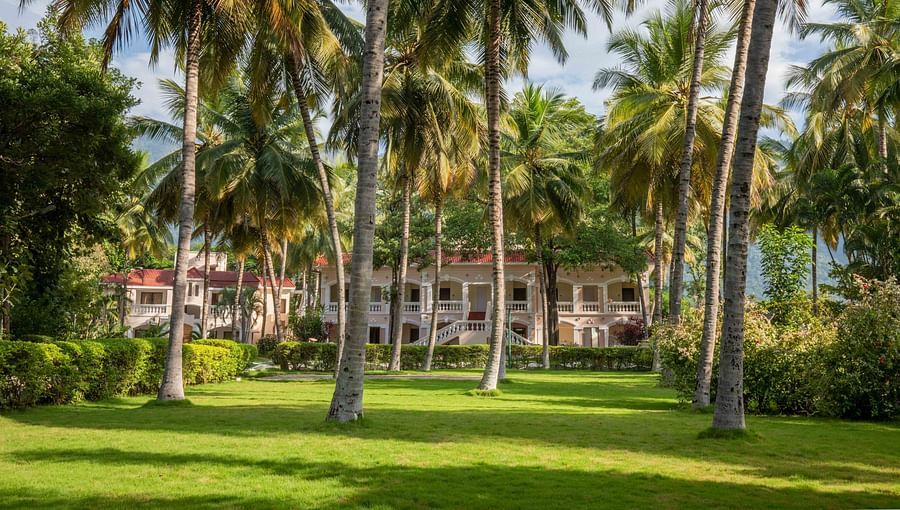 Scenic outdoor area with tall palm trees and lush green grass, leading to a distant building in a tropical setting - Black Thunder, Coimbatore