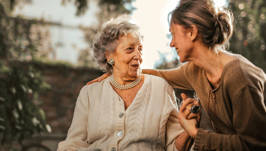 A photo showing a young girl affectionately spending time with a senior citizen at the golden hour.