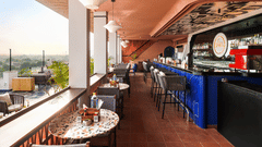 The bar extends into a cozy seating area overlooking a scenic landscape.