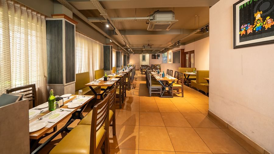 Image of a dining area with a photo frame mounted on the wall on the side at Hari Govindas, Siddappa Square.