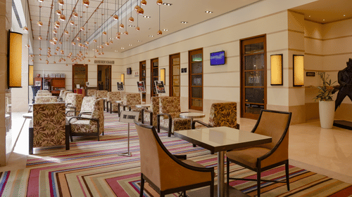 A charming tea lounge with comfortable seating, a chandelier, and stylish decor – Balaji Sarovar Premiere, Solapur.