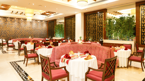 A roomy restaurant featuring sophisticated table arrangements and elaborate decor - Balaji Sarovar Premiere, Solapur