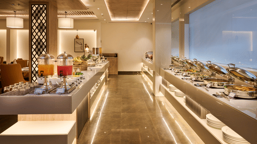 An image with seating facility on its left and buffet facility on the right at our restaurant