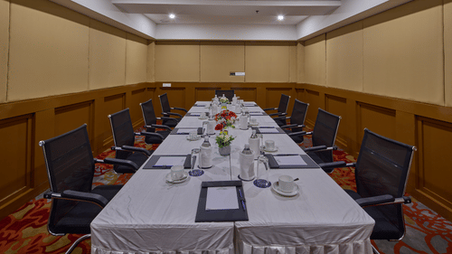 bottles, glasses, cups, and notepads on the table of the boardroom at Grand Continent, Mahabalipuram