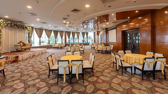  A large banquet hall or event space with multiple round tables set for a function - Pride Premier Dehradun