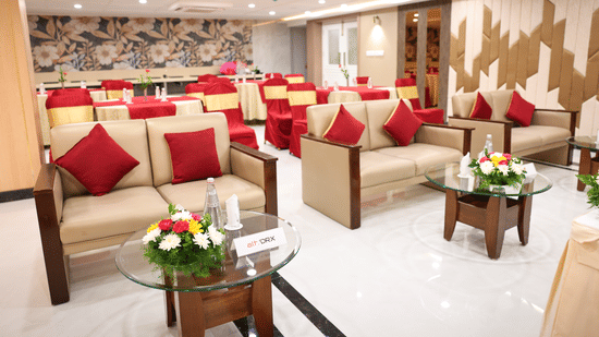 A lounge-style seating arrangement with sofas, centre tables, and floral accents inside the Coronet Ballroom at Monarch Hotel, Brigade Road.