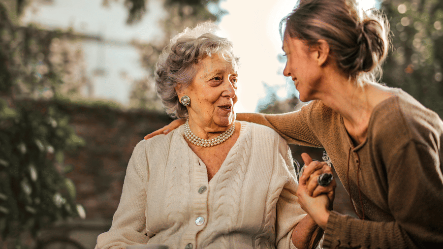 A photo showing a young girl affectionately spending time with a senior citizen at the golden hour.