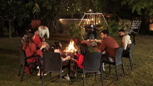 A group of poeple enjoying a bonfire evening outdoors at The Golden Tusk, Jim Corbett.