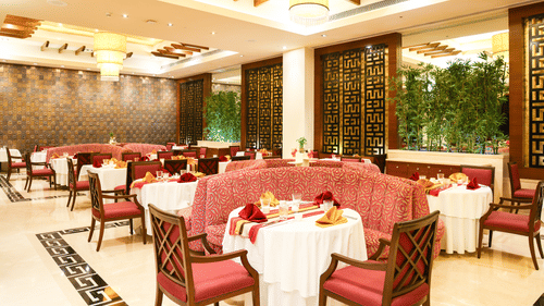 A roomy restaurant featuring sophisticated table arrangements and elaborate decor - Balaji Sarovar Premiere, Solapur