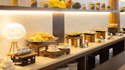 A close-up view of a well-presented buffet table with an assortment of snacks and desserts - Pride Premier Dehradun