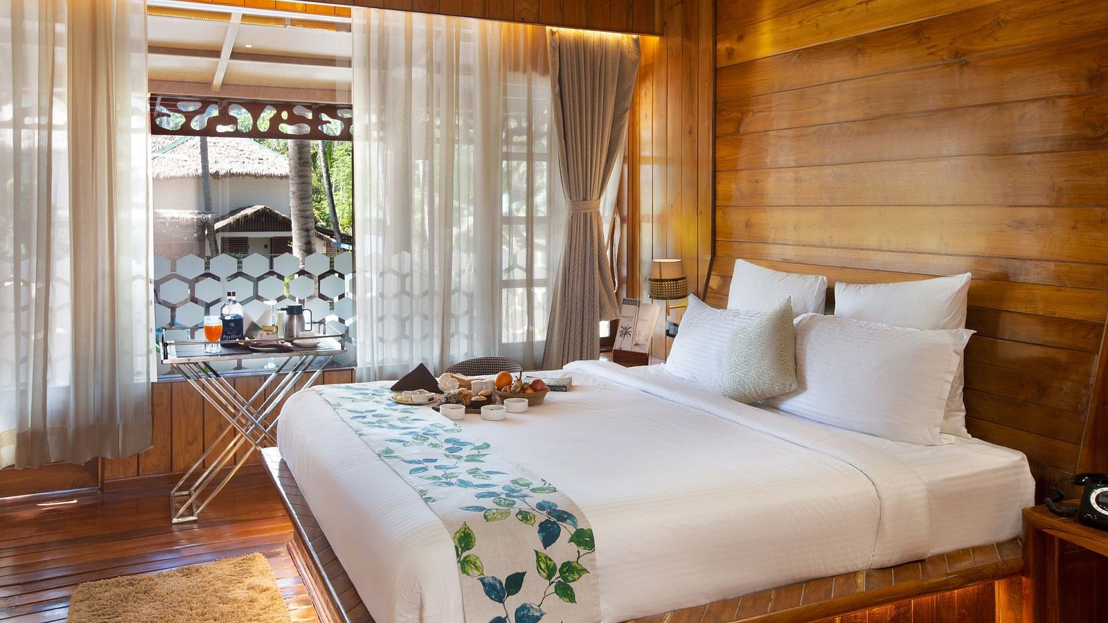 Coral Turquoise at Coral Reef Resort and Spa in Havelock featuring a plush bed placed next to the large window which extended to the doorway to the balcony