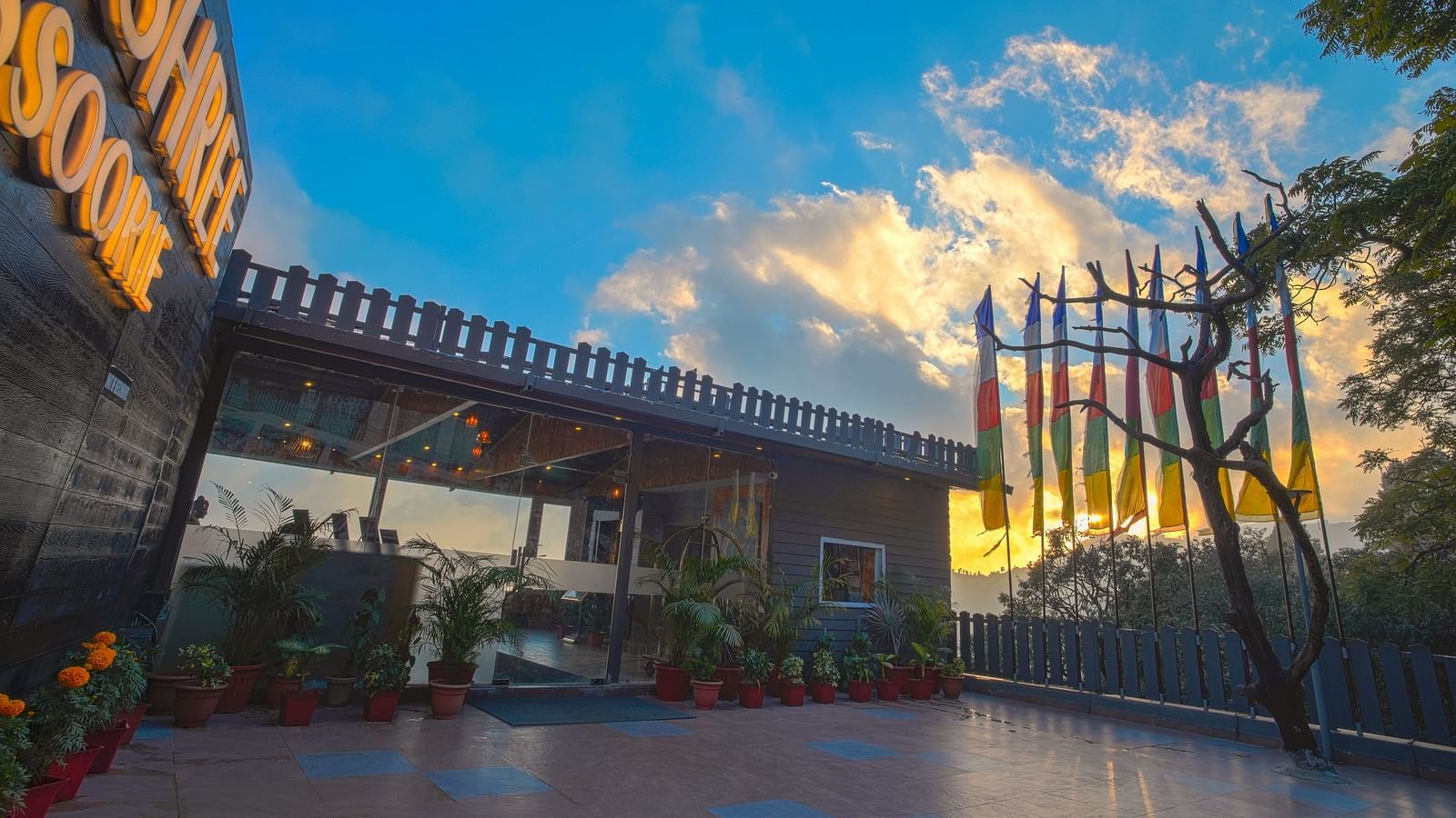 A facade image of Yashshree, Mussoorie surrounded by greenery and a backdrop of clouds - NOT USED