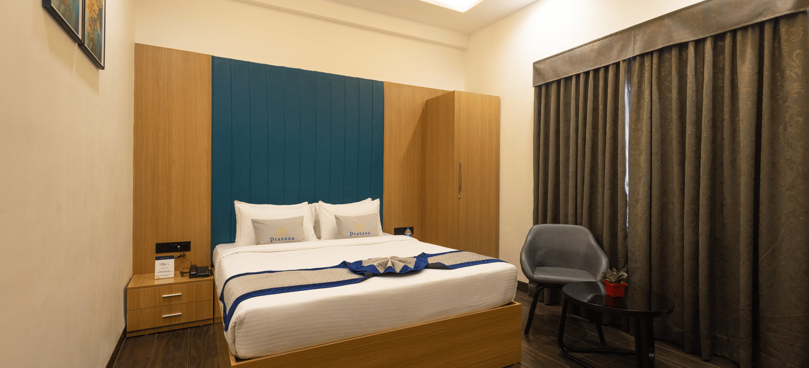 Interior view of a guest room showing the bed and window with closed curtains at Pravasa Stay Luv Kush, Indore.