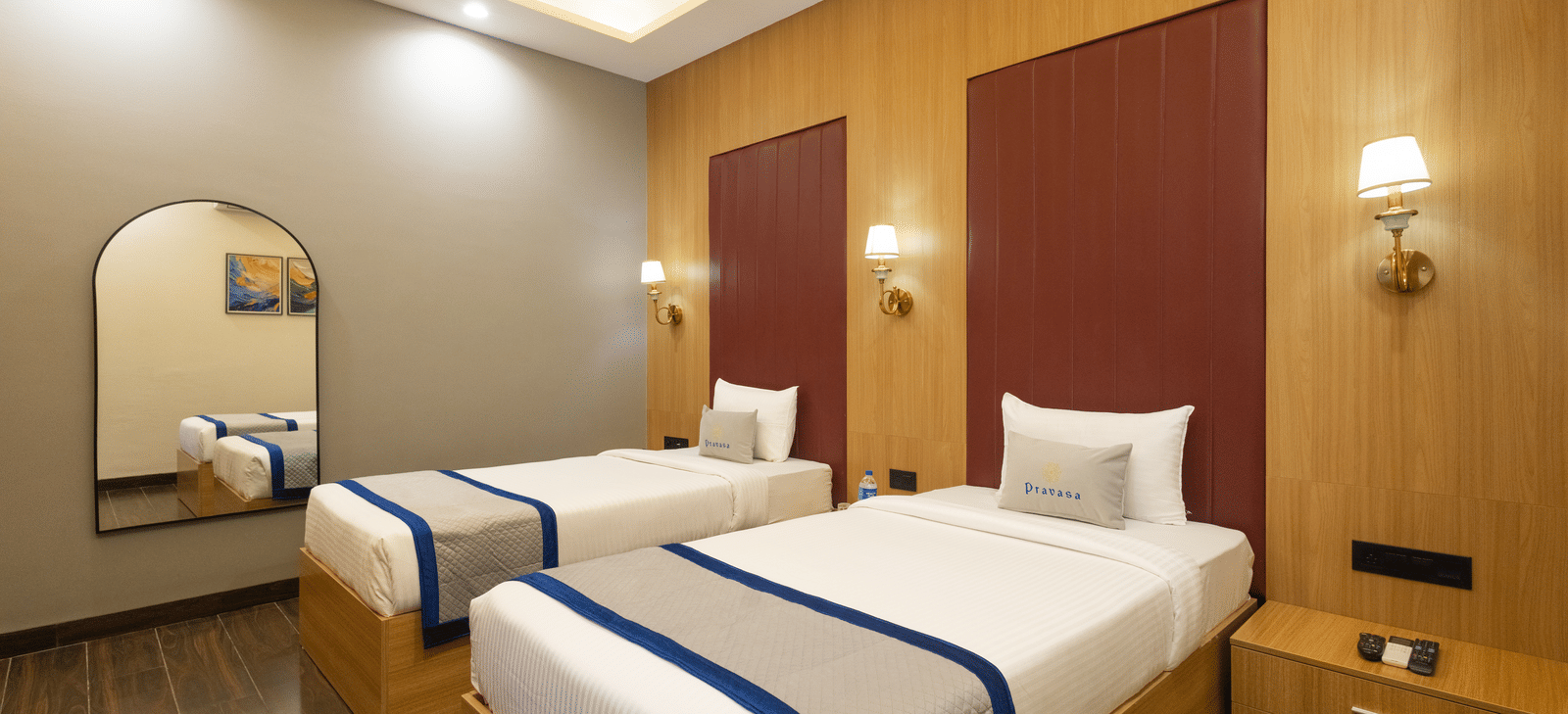 Interior view of a guest room showing 2 single beds and a mirror at Pravasa Stay Luv Kush, Indore.