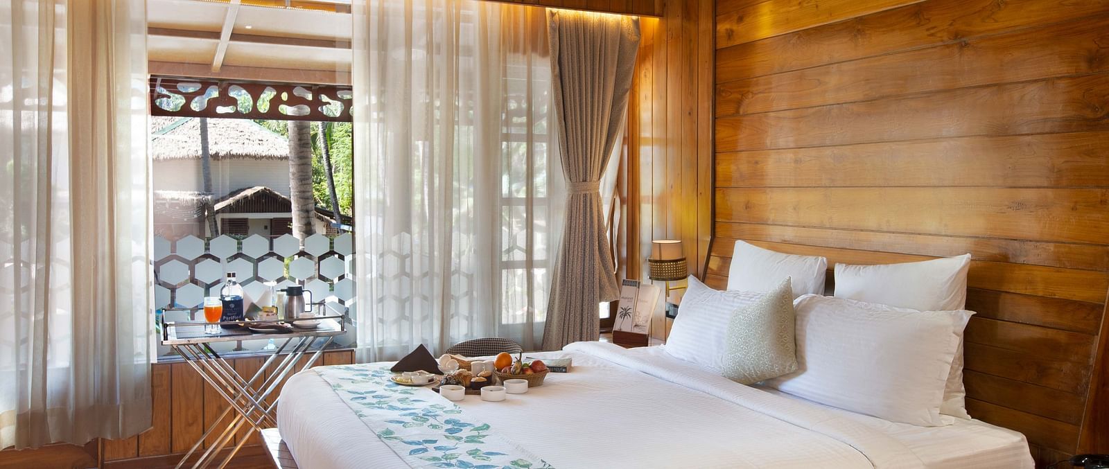 Coral Turquoise at Coral Reef Resort and Spa in Havelock featuring a plush bed placed next to the large window which extended to the doorway to the balcony