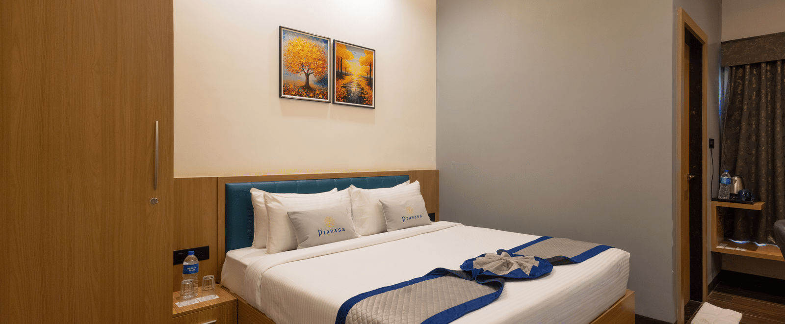 Interior of a guest room showing the bed and bedside table at Pravasa Stay Luv Kush, Indore.