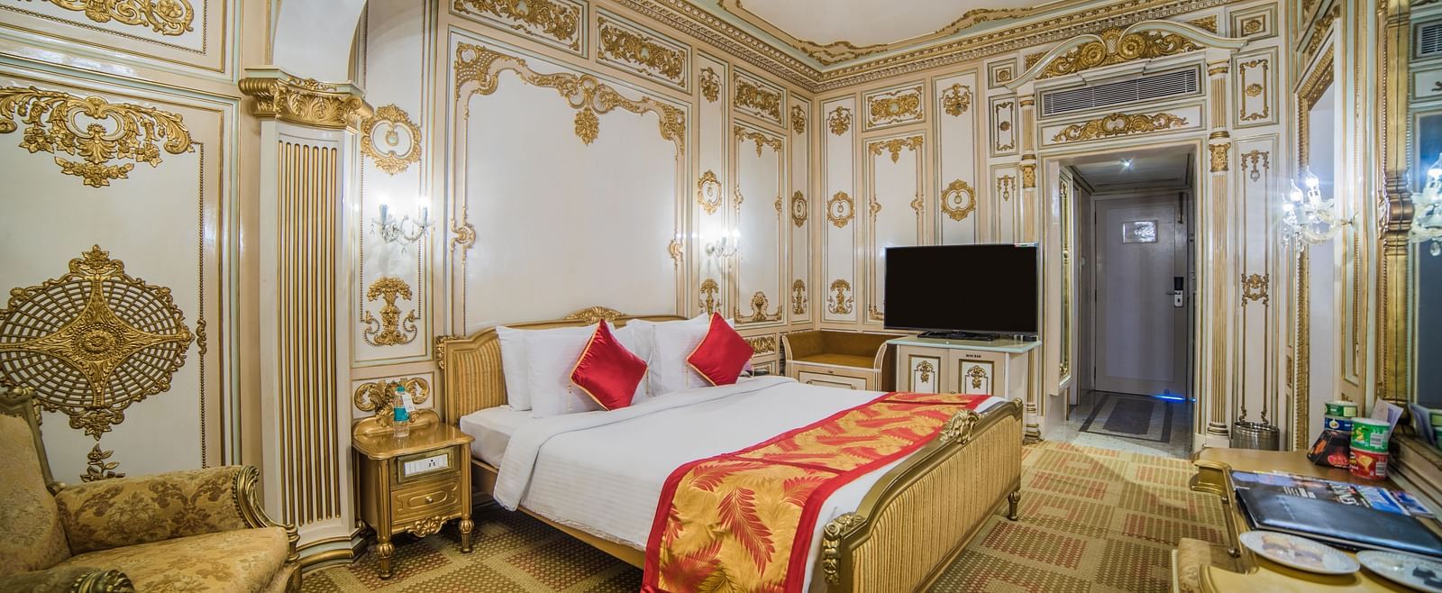 Grand bedroom with regal gold decor at  Sitara Luxury Hotel in Hyderabad near Ramoji Film City.