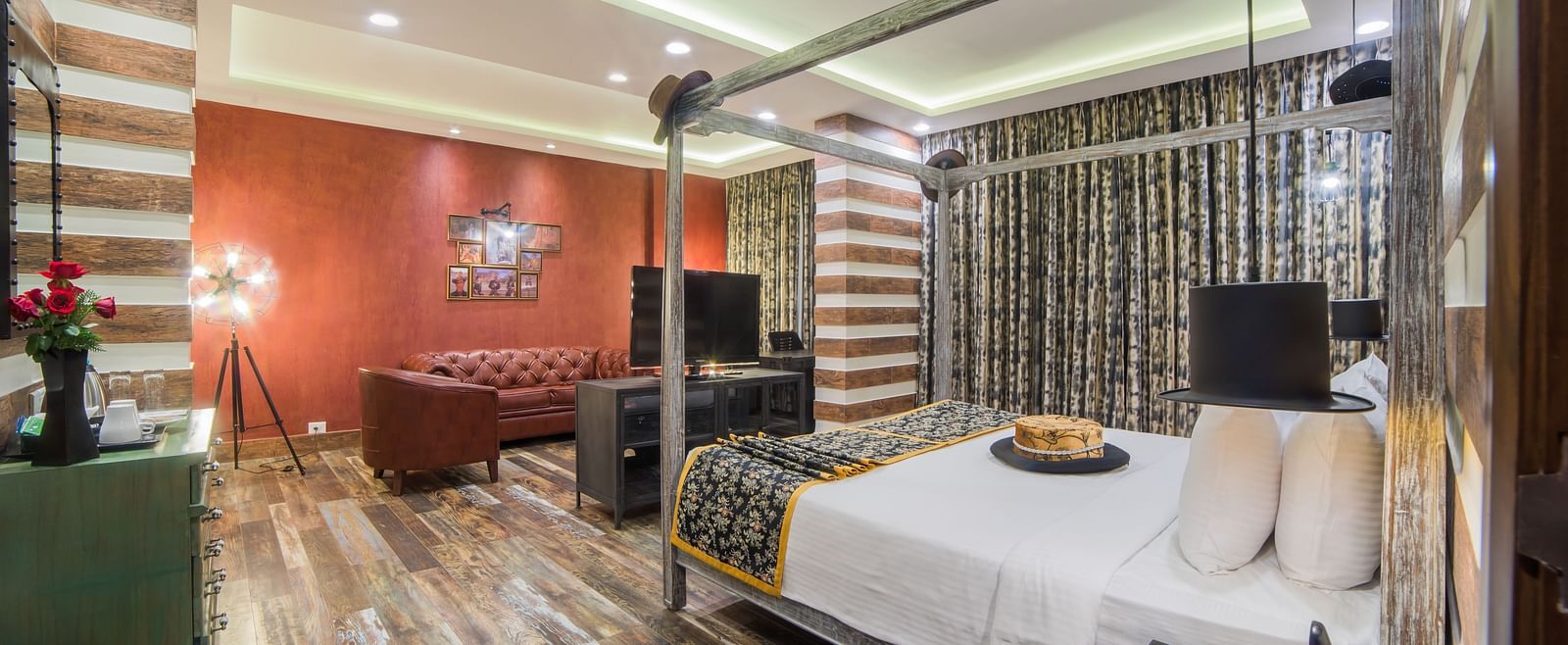 A modern hotel room with striped wall design, contrasting red accent wall, and contemporary furnishings A grand hotel suite with an opulent red and white decor, large bed, and seating area, reflecting a traditional style at Sitara Luxury Hotel in Hyderabad