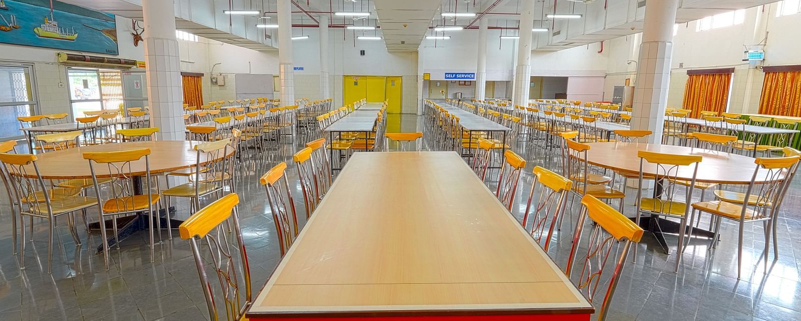 A dining hall with a long table paired with six chairs at Sahara - Group Dining in Hyderabad.
