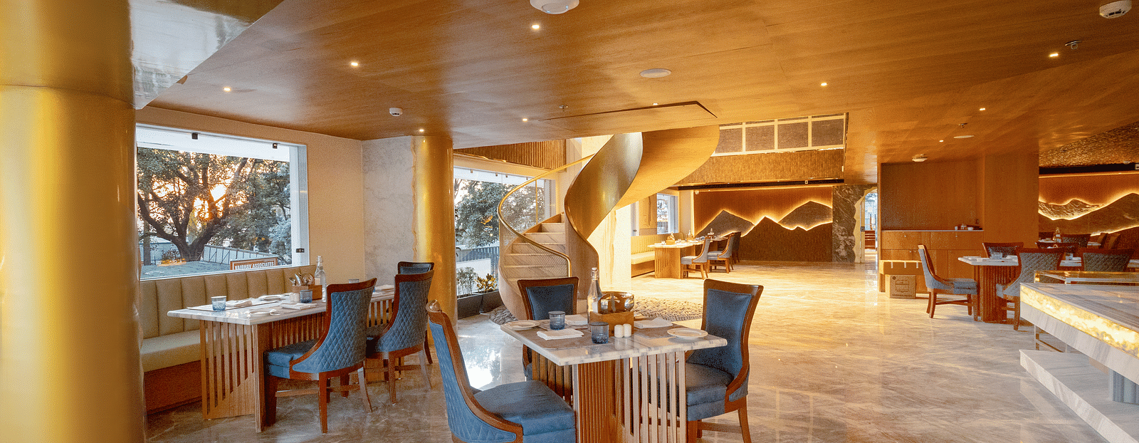 Image of a dining space with seating area and wooden ceiling at Auradoon, Dehradun.