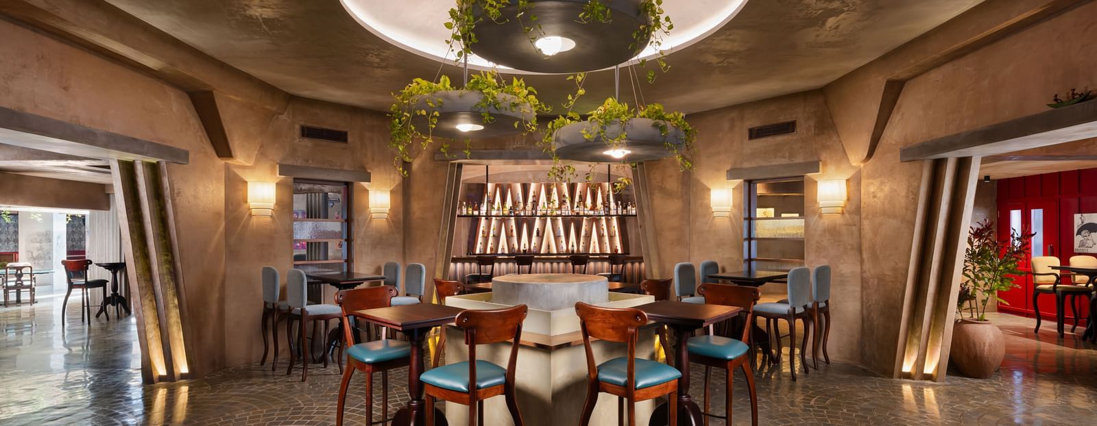 A dining area with tables and chairs under a circular hanging light fixture | Shilton Hotels