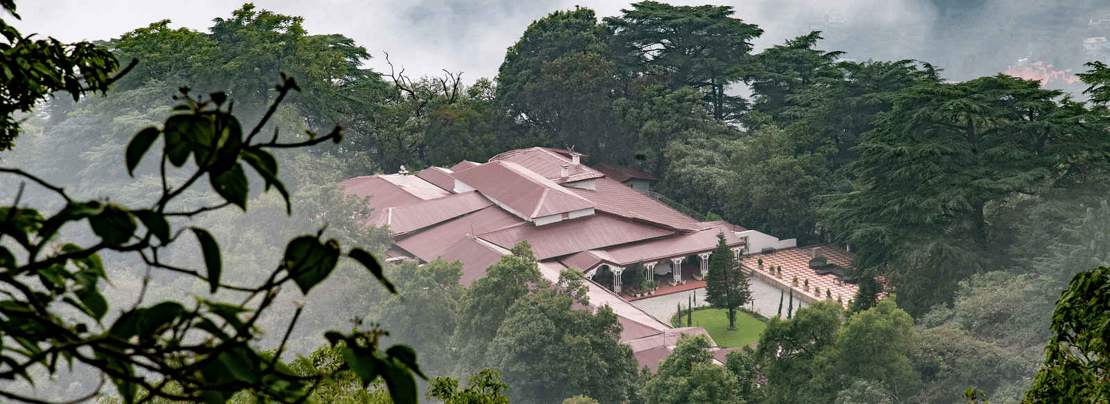 Facade of the The Claridges Nabha Residence in Mussoorie during a foggy day - Claridges Collection