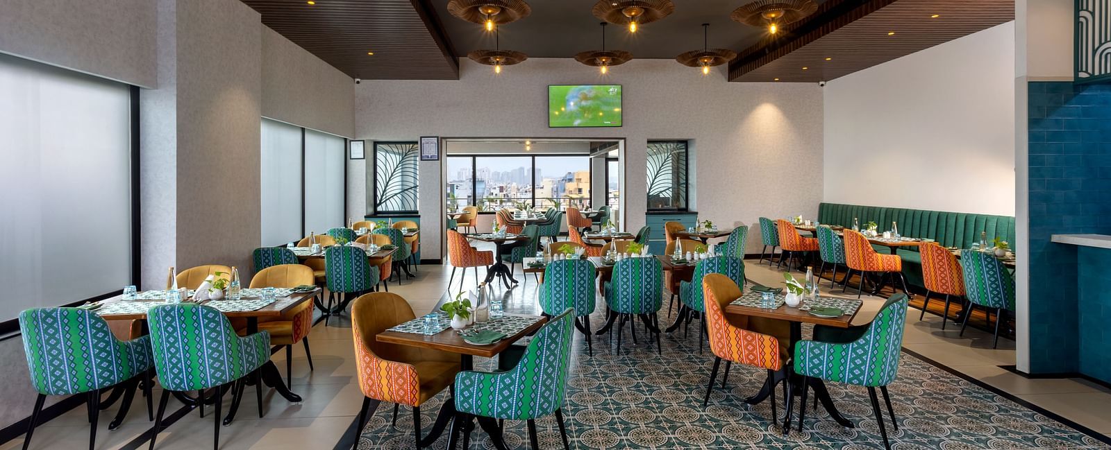 Spacious restaurant at Shalimar in Zibe Luxe Hyderabad by GRT Hotels offering a bright, city-facing setting with stylish ceiling lights.