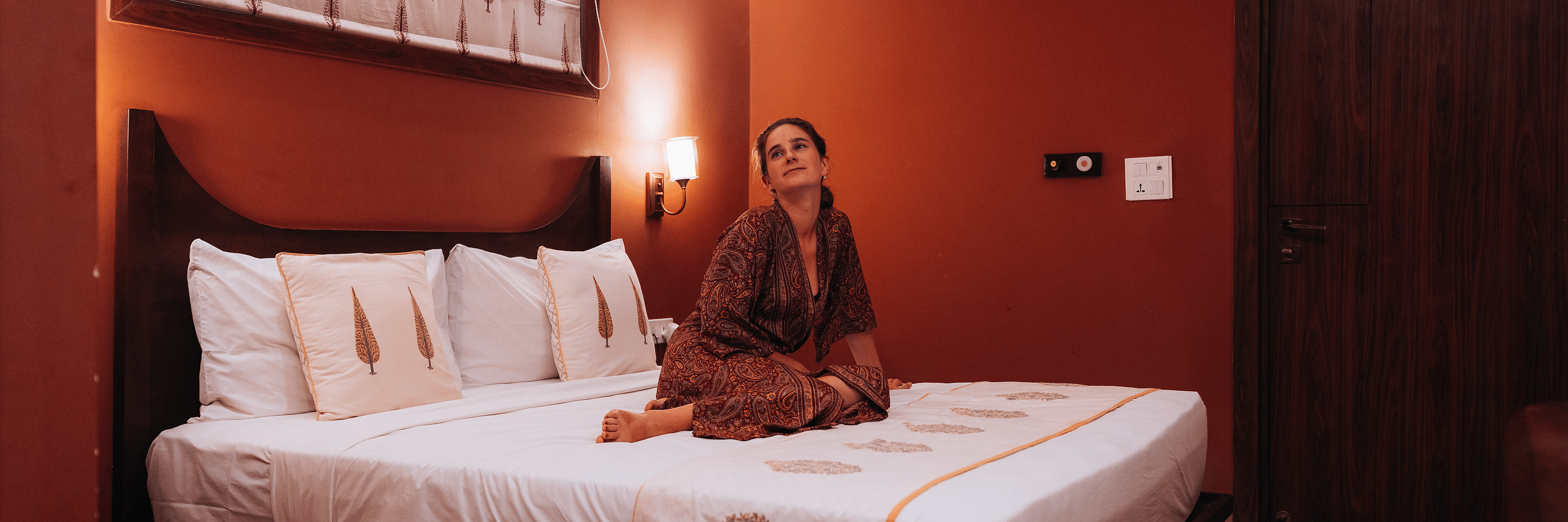 A person sitting on a bed in a room at Ekaa Villa & Kitchen