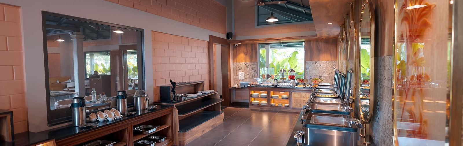 Indoor dining area with wooden tables, warm lighting, and modern decor at Trishvam Symphony, Krishnagiri.