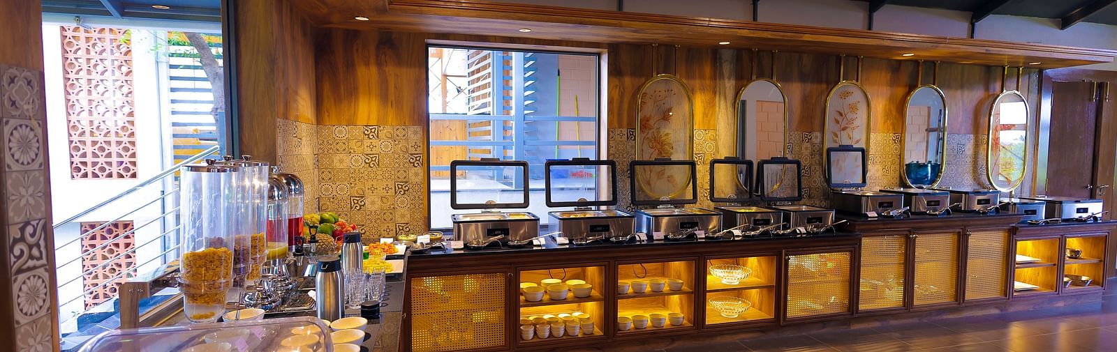 Buffet counter setup in a stylish wooden-themed dining area at Trishvam Symphony, Krishnagiri.