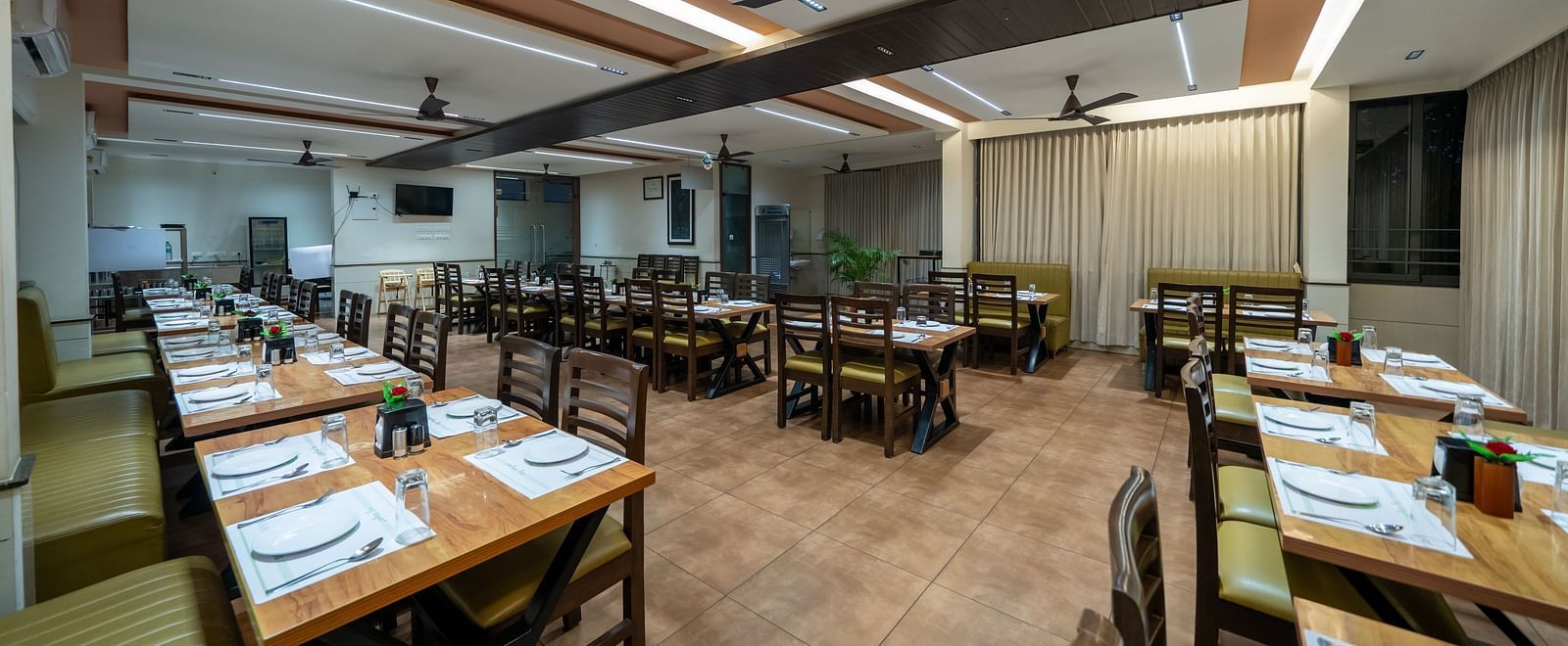 Diagonal view of the dining area at Hari Govinda's, with a table and chairs neatly arranged beside it