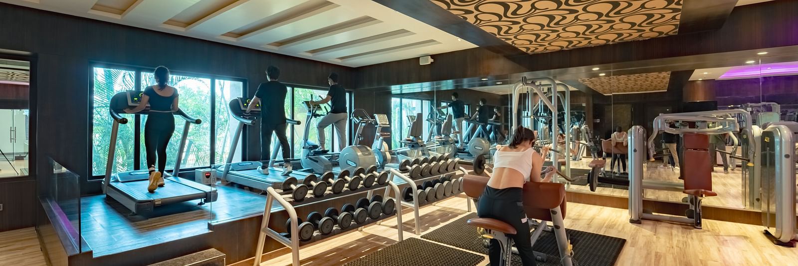Individuals exercising in the spacious gym at Crescent Spa & Resort, Indore