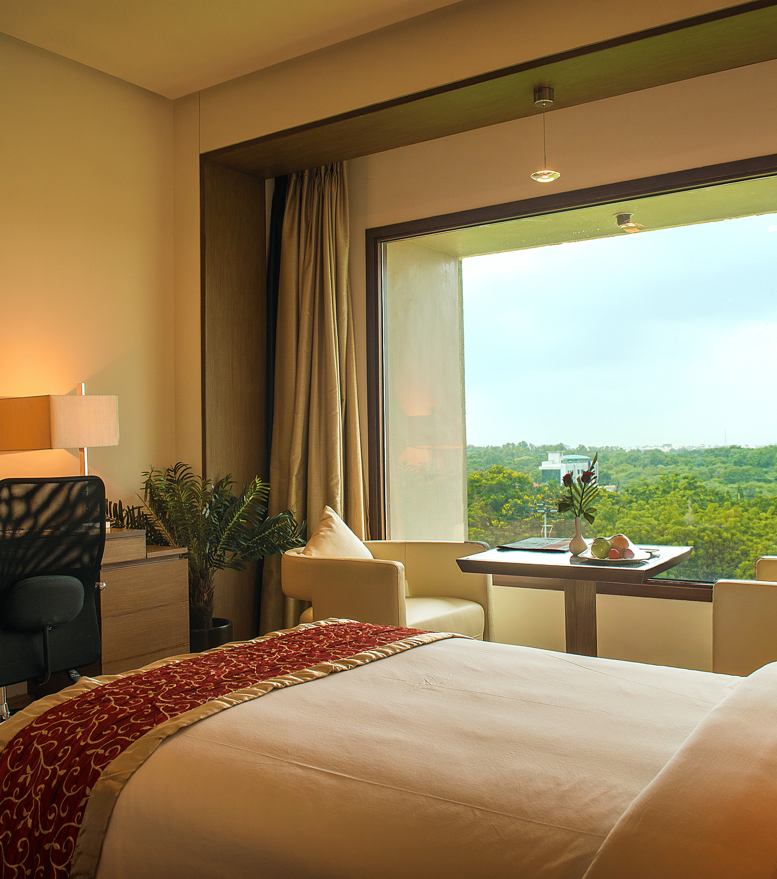 Hotel bedroom with large window, desk, and scenic outdoor view - Narayani Heights Hotel & Resorts