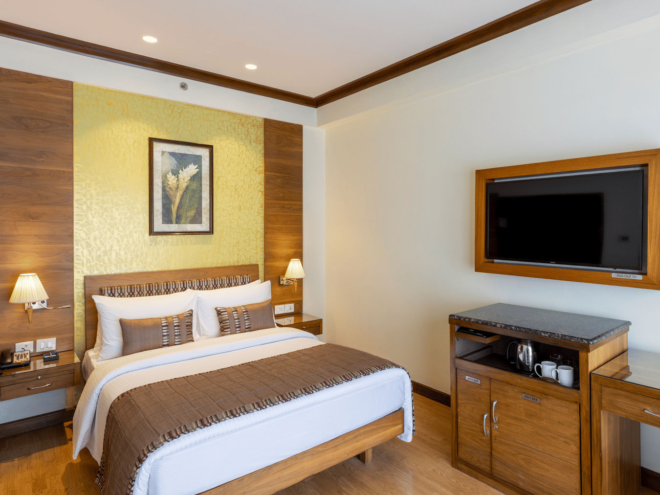 Business Club Room with a bed, wooden TV console and framed artwork at Kenilworth Hotel, Kolkata.