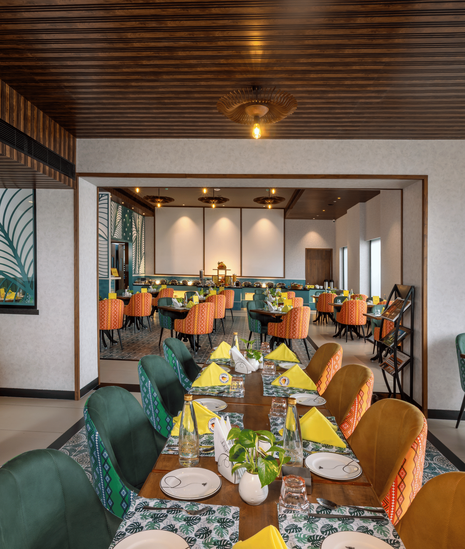 Dining space at Shalimar Restaurant in Zibe Luxe Hyderabad by GRT Hotels, offering colourful seating, ceiling lights, artistic decor, and best food in Hyderabad.