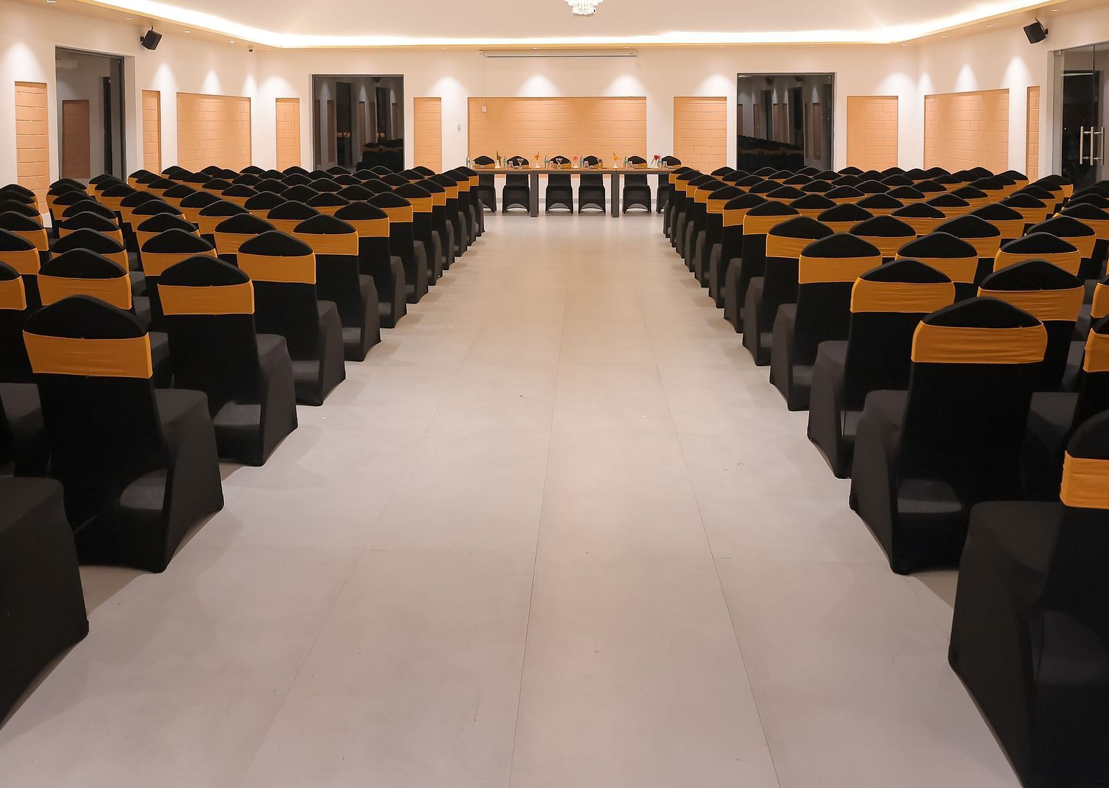 Another view of the main conference hall at Trishvam Symphony, Krishnagiri, with symmetrical lighting and ample seating capacity.