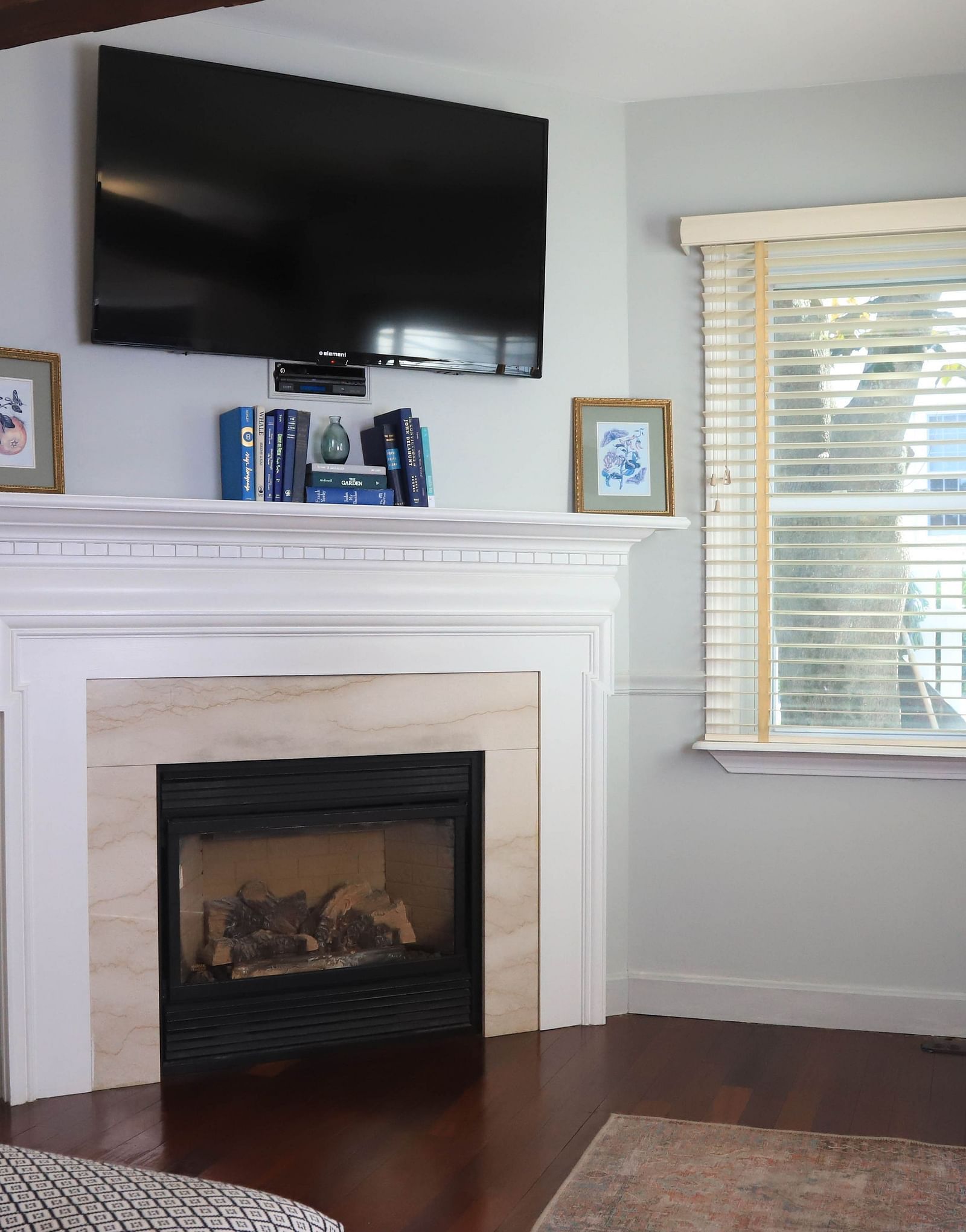 Room with a fireplace, TV, and window at Hartstone Inn.