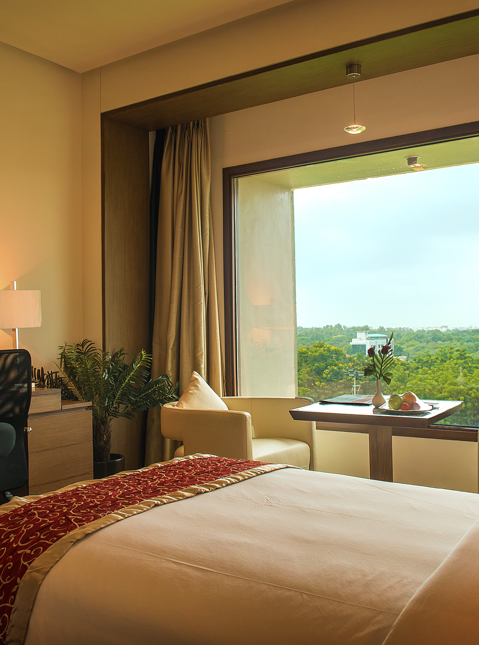 Hotel bedroom with large window, desk, and scenic outdoor view - Narayani Heights Hotel & Resorts