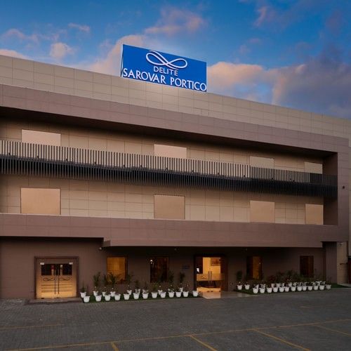 A facade image of a hotel with a sign board of the hotel name on the top