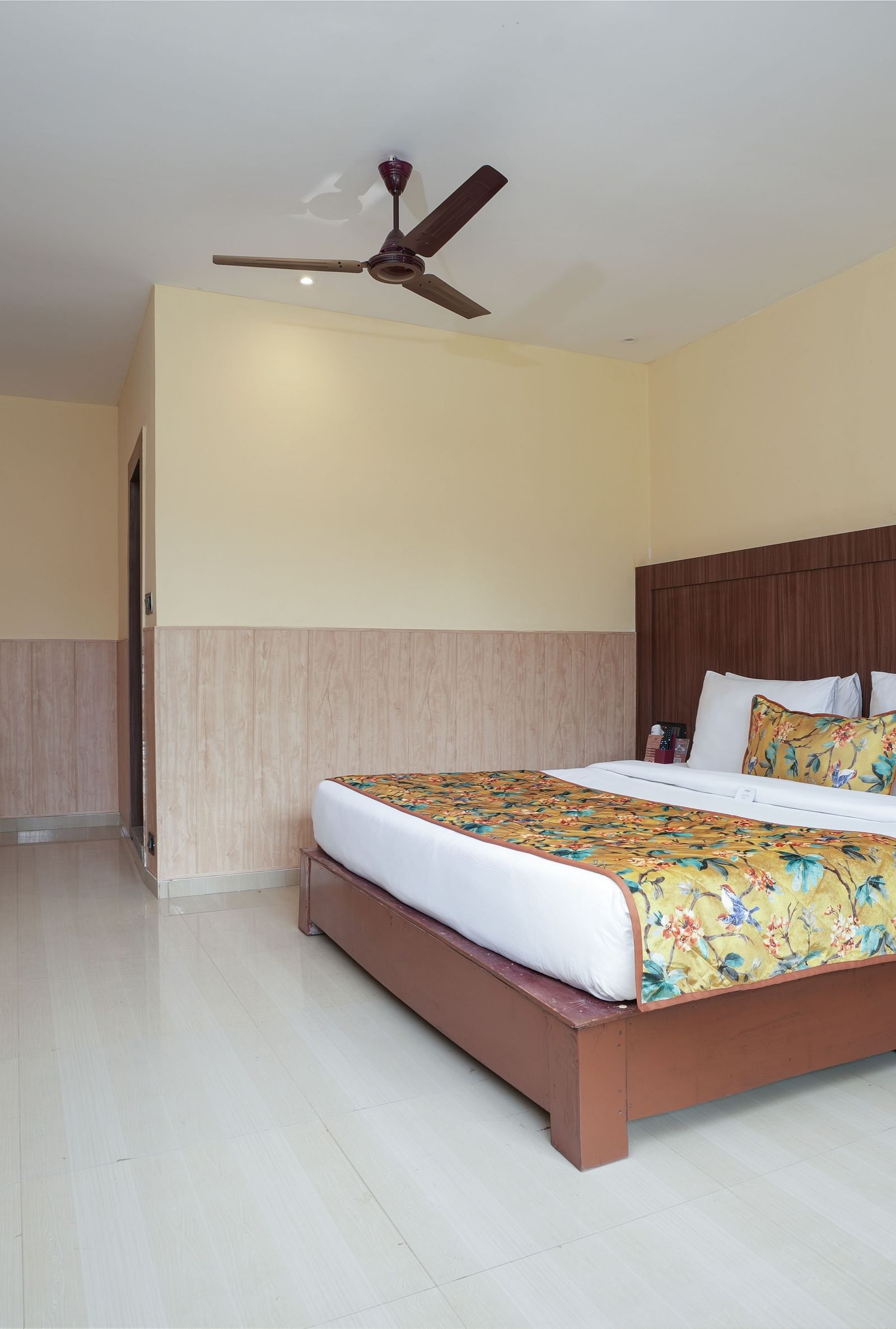 Premium Room with a large bed, wooden furniture and storage, mini fridge, and wall-mounted TV at Summit Green Lake Tea Resort & Spa, Kaziranga