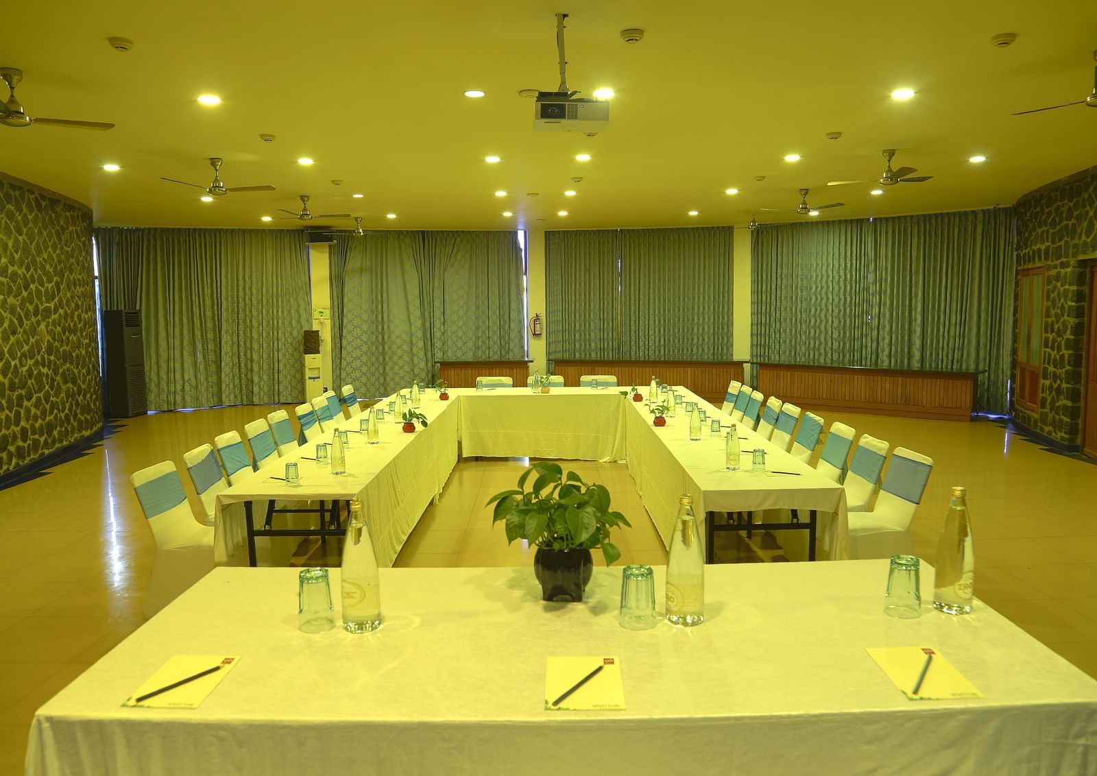 An image of a meeting hall with board room seating, bright lighting, and meeting amenities - Great Trails Yercaud by GRT Hotels