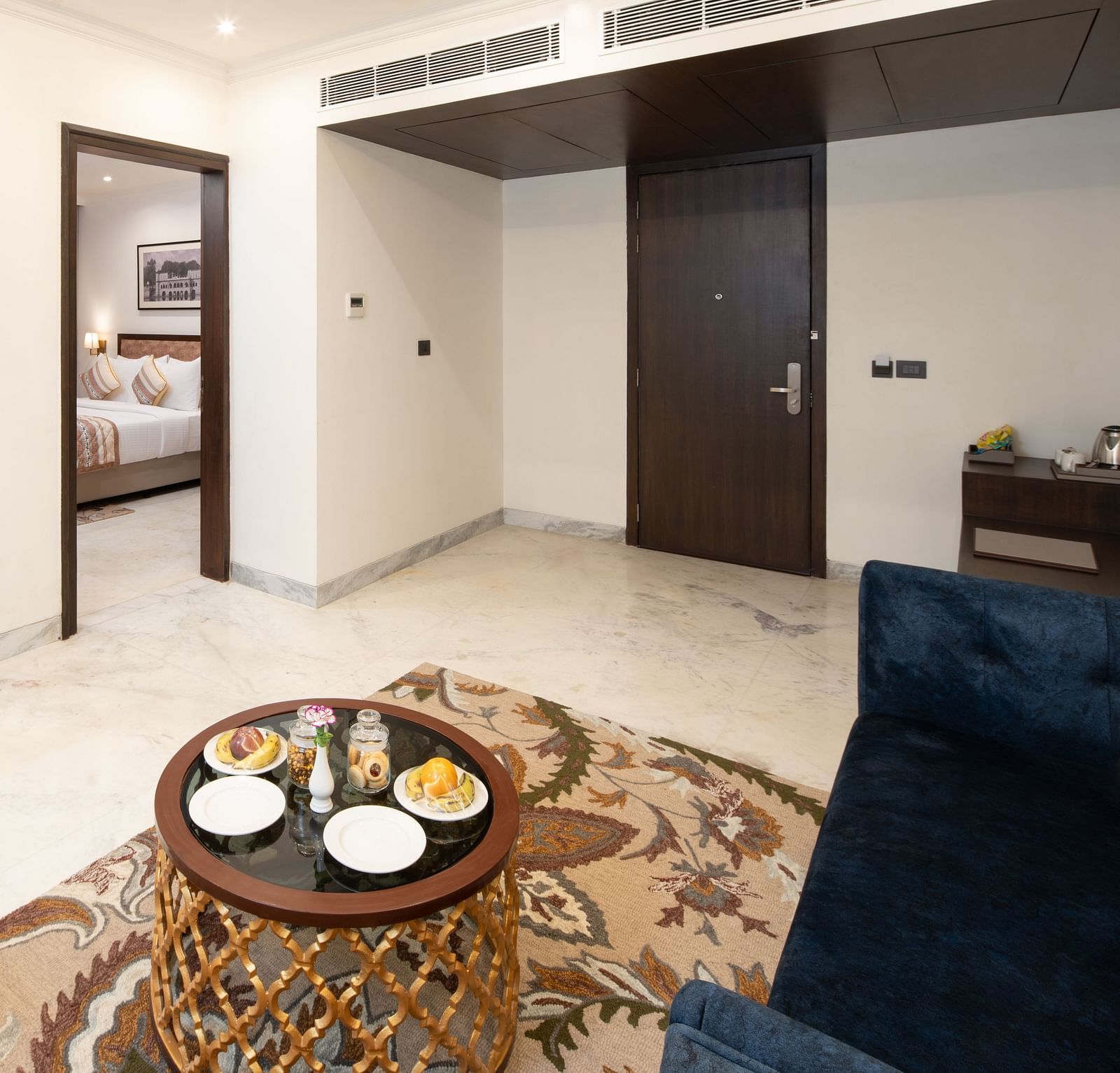 An image of a seating area with sofa set, centre table, flat TV screen and a photo frame hanged on the wall -  Brij Eternity, Vrindavan