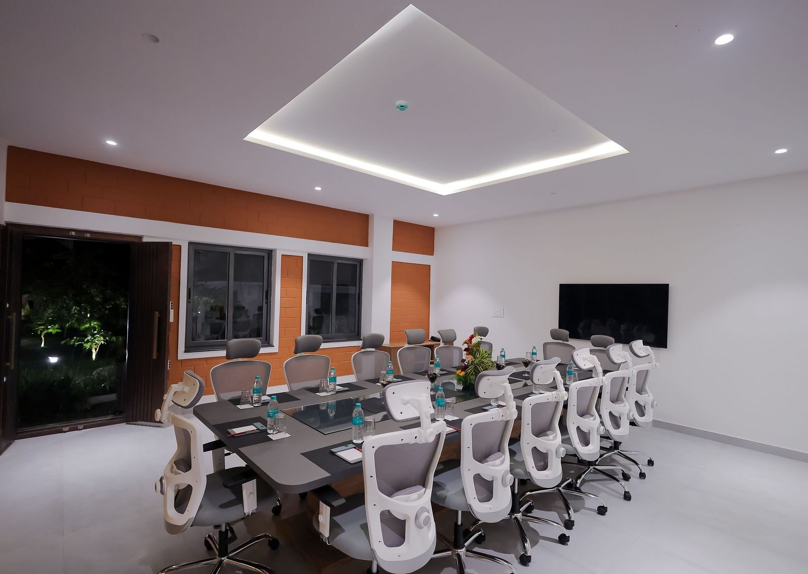 Boardroom with glass window at Trishvam Symphony, Krishnagiri, offering a modern ambience and a collaborative setting.