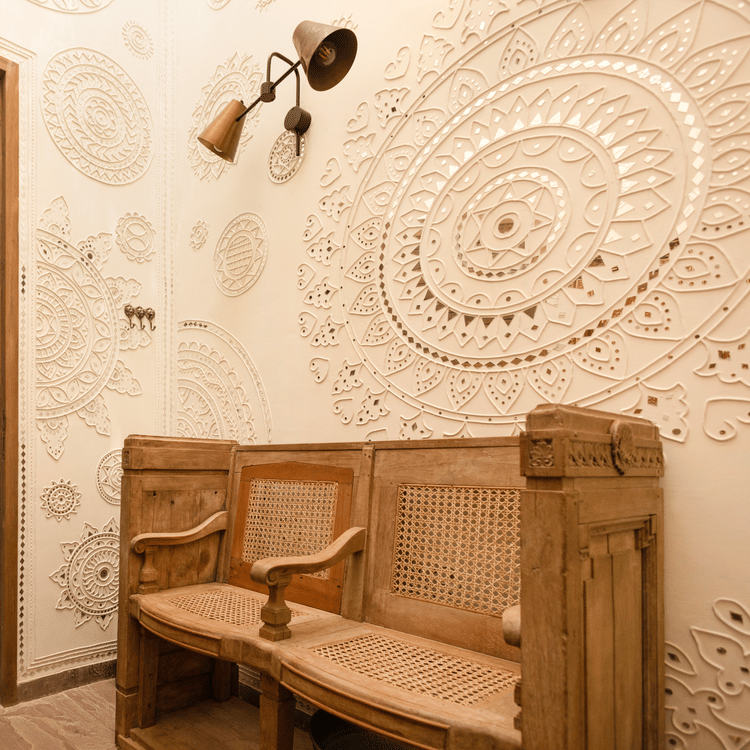 A cosy spa lounge at Aramness welcomes guests with carved wooden furniture and calming earthy tones.