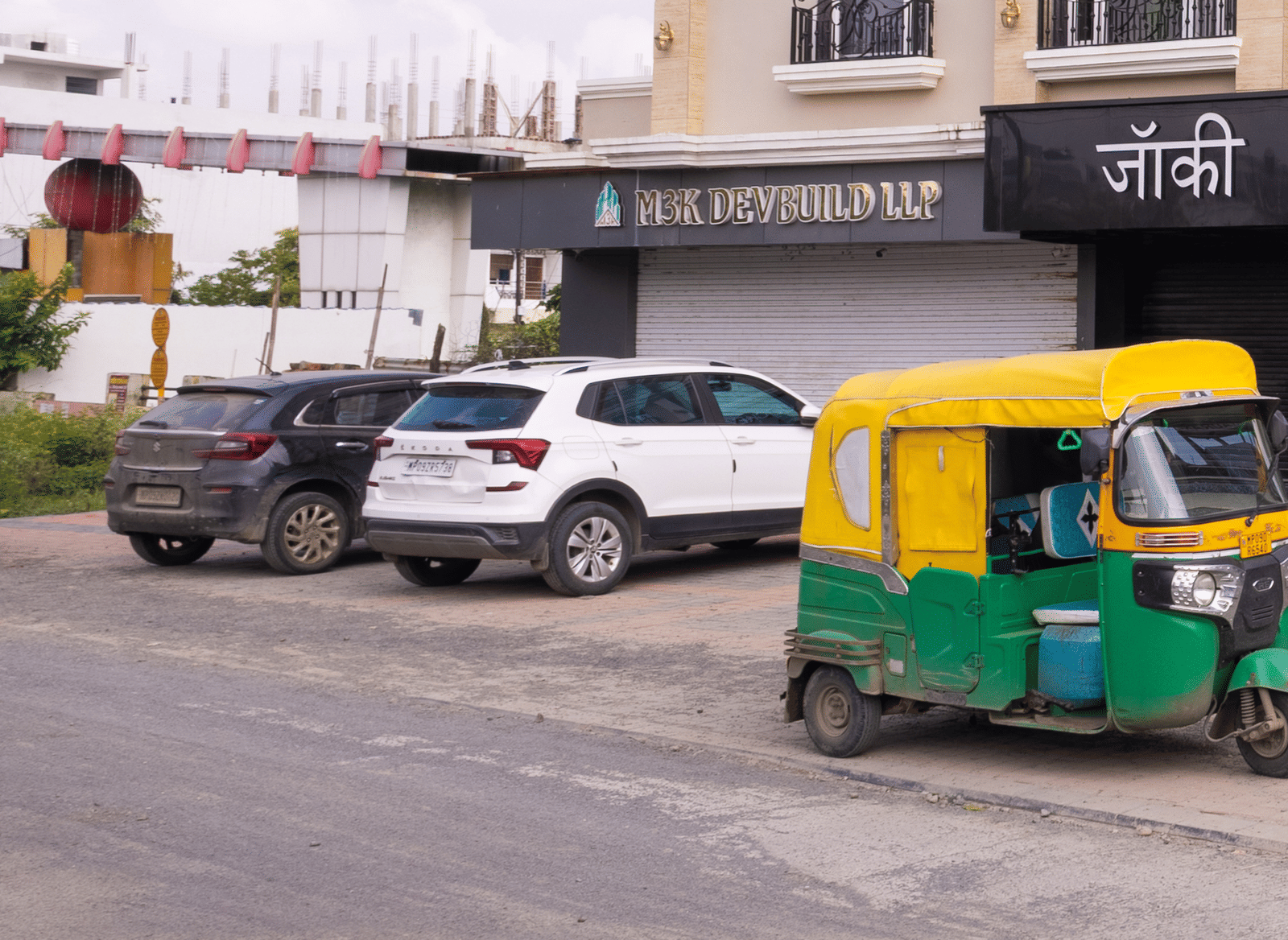 Exterior full view of the three-storey building of Pravasa Stay Luv Kush, Indore with a vehicle visible nearby.